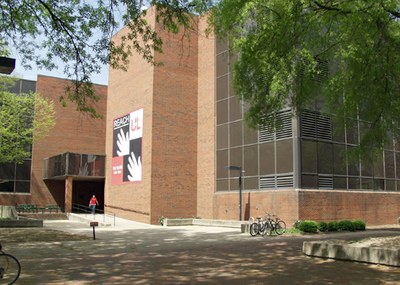 Strickler Hall with a bicycle rack and shade from the trees